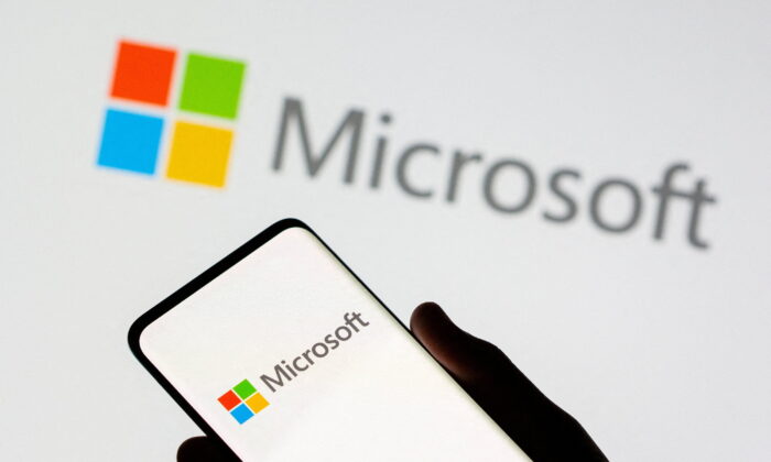 A phone is seen in front of a Microsoft logo displayed in this illustration taken on July 26, 2021. (Dado Ruvic/Illustration/Reuters)