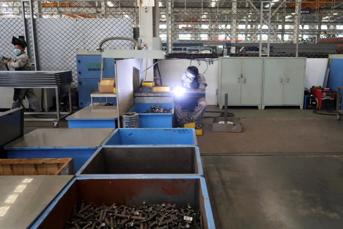 Employees work on the production line at Jingjin filter press factory in Dezhou, Shandong province, China, on Aug. 25, 2022. (Siyi Liu/Reuters)