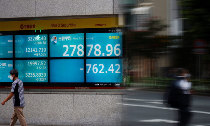 A man wearing a protective mask amid the coronavirus disease (COVID-19) outbreak, walks past an electronic board displaying Japan's Nikkei index outside a brokerage in Tokyo, Japan, on Aug. 29, 2022. (Kim Kyung-Hoon/Reuters)