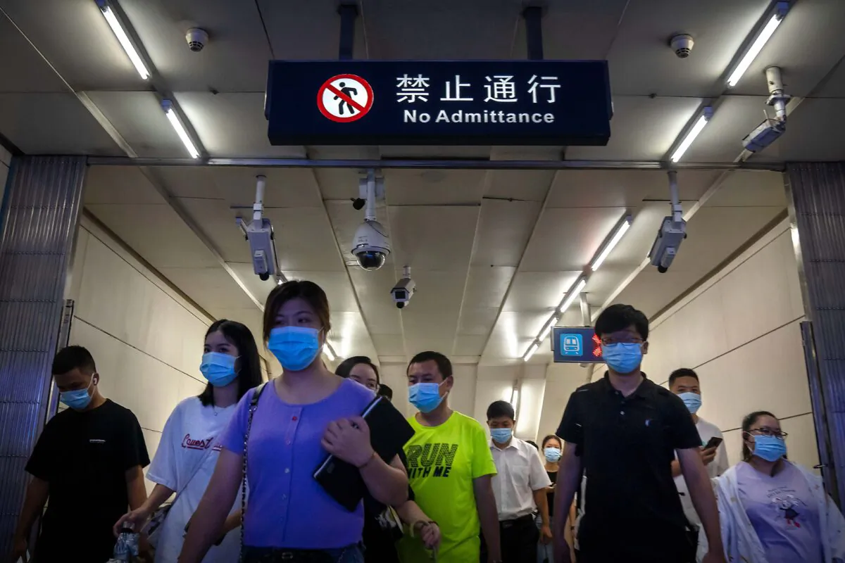 Commuters walk through a subway station during the morning rush hour in the central business district in Beijing on Aug. 9, 2022. (Mark Schiefelbein/AP Photo)
