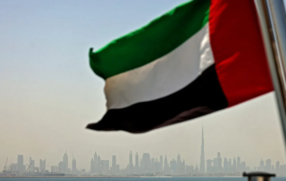 The Emirati flag sways in the wind in Dubai, United Arab Emirates, on June 3, 2022, as the skyline of Dubai is seen in the background. (Karim Sahib/AFP via Getty Images)