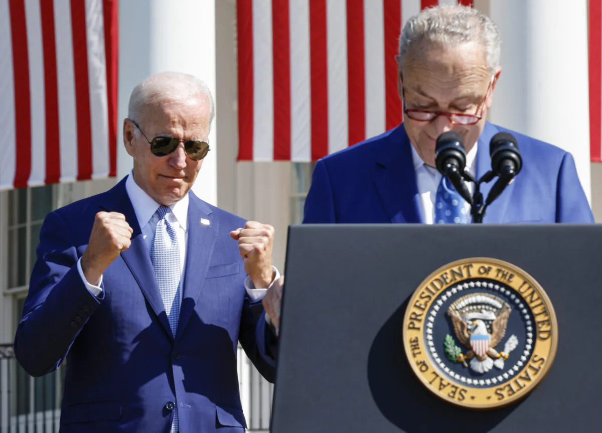 President Joe Biden (L) reacts as Senate Majority Leader Chuck Schumer (D-N.Y.) speaks before Biden signs the CHIPS and Science Act of 2022 during a ceremony on the South Lawn of the White House in Washington on Aug. 9, 2022. (Chip Somodevilla/Getty Images)
