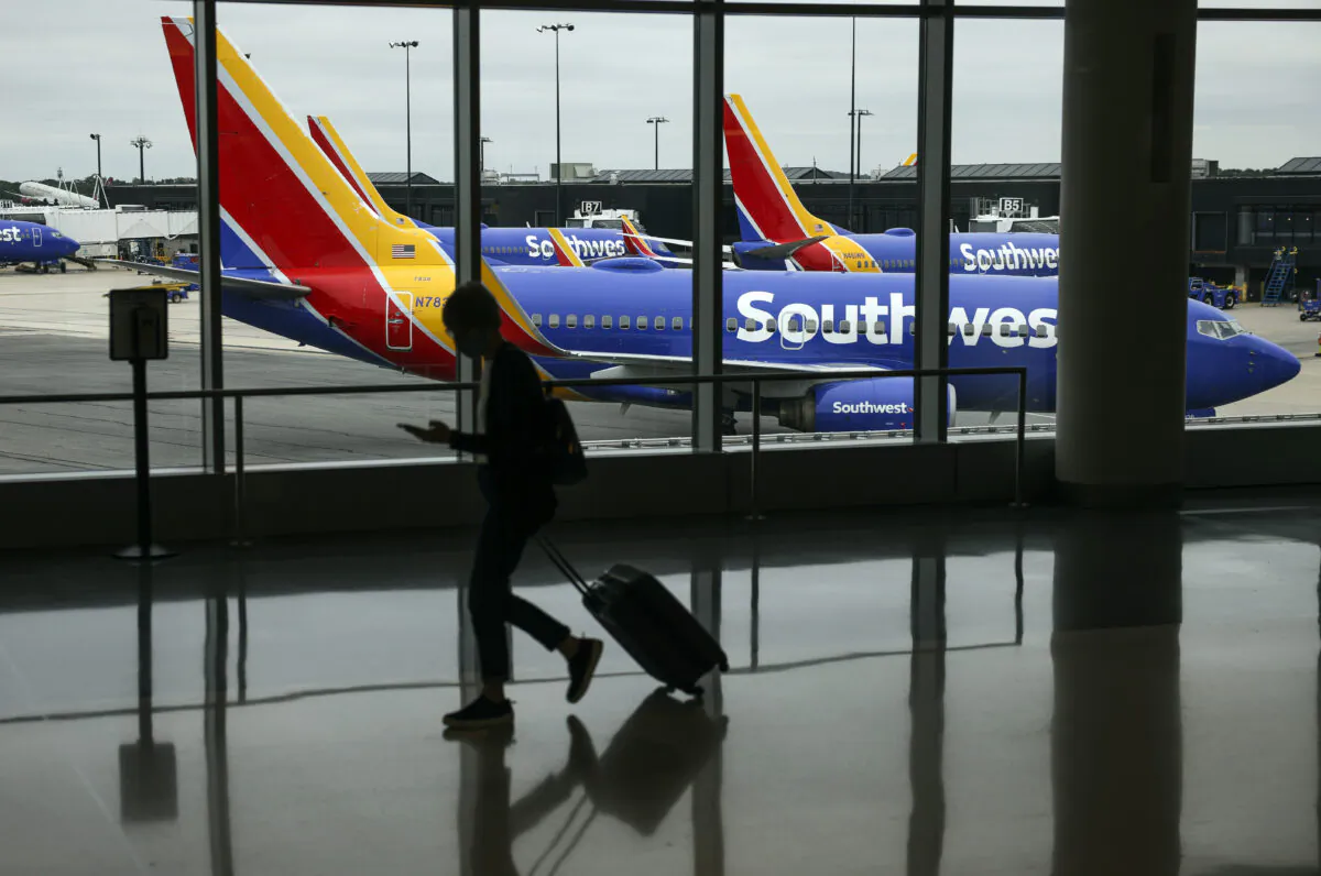 A traveler walks past a Southwest Airlines airplane as it taxies from a gate at Baltimore Washington International Thurgood Marshall Airport on October 11, 2021 in Baltimore, Maryland. (Kevin Dietsch/Getty Images)