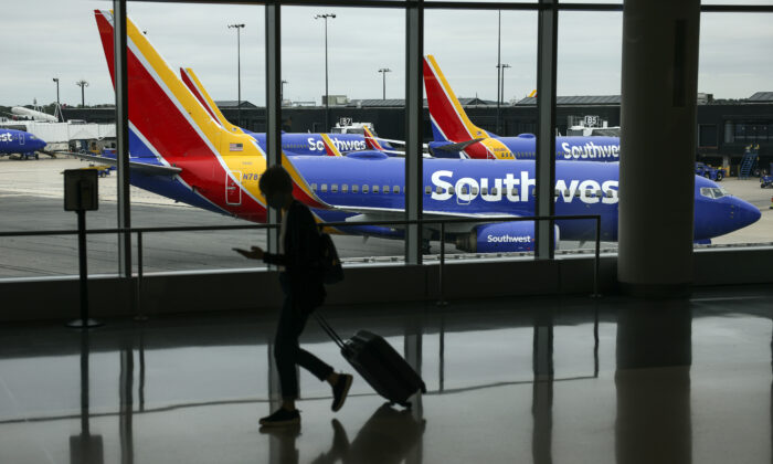 A traveler walks past a Southwest Airlines airplane as it taxies from a gate at Baltimore Washington International Thurgood Marshall Airport on October 11, 2021 in Baltimore, Maryland. (Kevin Dietsch/Getty Images)