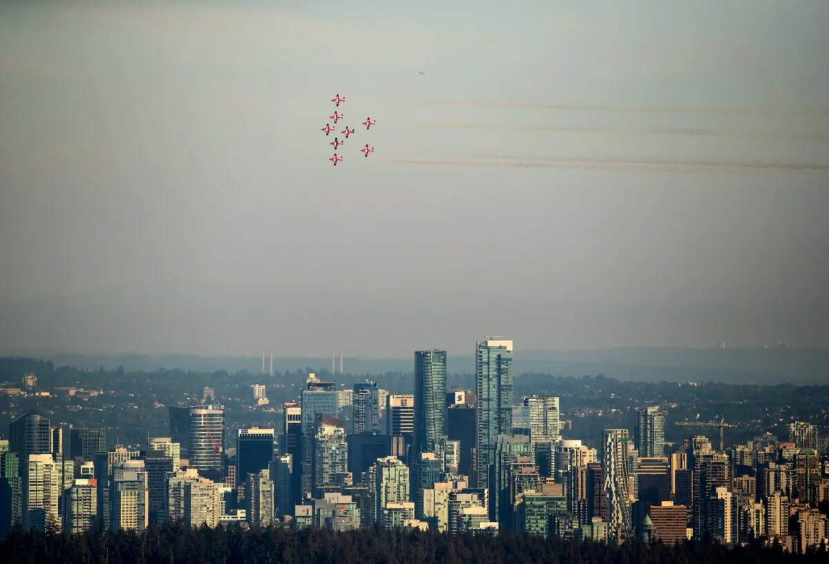 The Canadian Forces Snowbirds air demonstration team fly over the downtown skyline as part of the Celebration of Light fireworks festival, in Vancouver, on July 27, 2022. (The Canadian Press/Darryl Dyck)