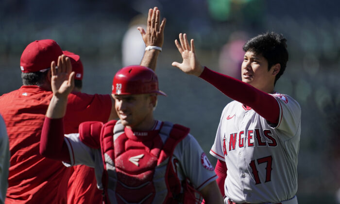 Los Angeles Angels' Max Stassi, middle, and Shohei Ohtani (17) celebrate with teammates after the Angels defeated the Oakland Athletics in a baseball game in Oakland, Calif., Aug. 10, 2022. (Jeff Chiu/AP Photo)