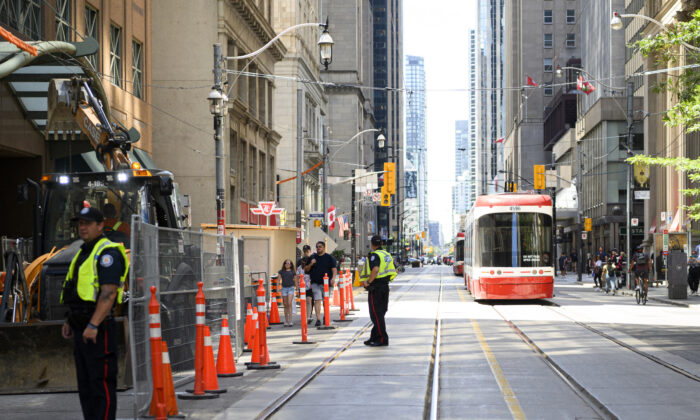 Police direct traffic in Downtown Toronto after a power outage affected traffic lights, on August 11, 2022. (The Canadian Press/Christopher Katsarov)