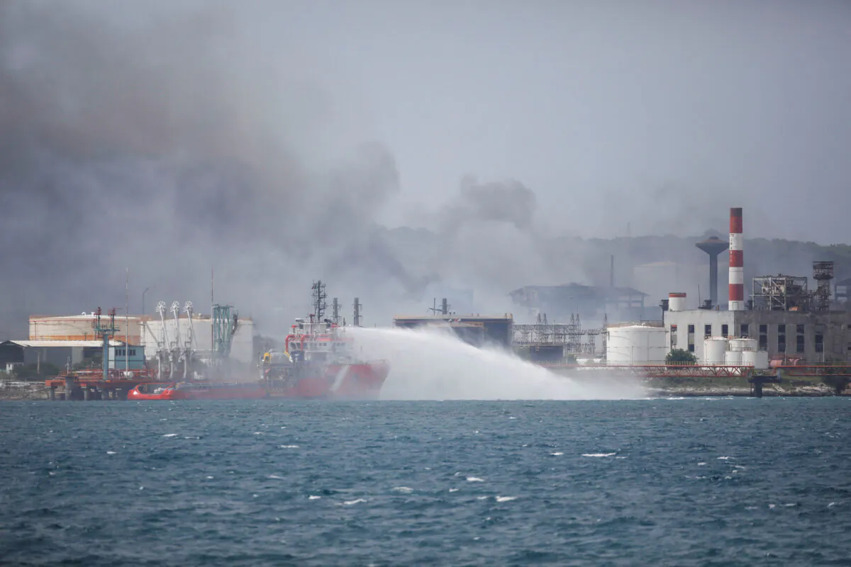 Mexico's offshore supply ship Bourbon Artabaze throws water in an area of tanks that exploded near Cuba's supertanker port in Matanzas, Cuba, on Aug. 10, 2022. (Alexandre Meneghini/Reuters)