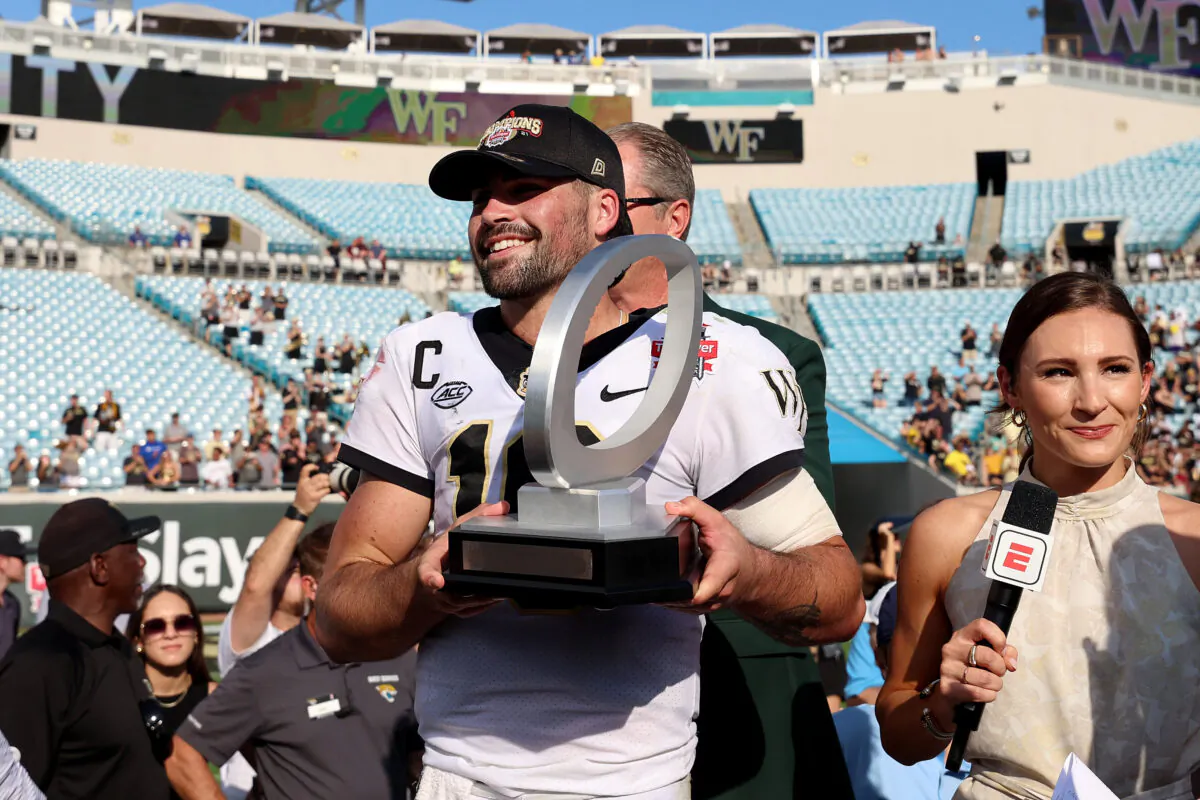 Sam Hartman #10 of the Wake Forest Demon Deacons holds the MVP trophy following a 38–10 victory against the Rutgers Scarlet Knights in the TaxSlayer Gator Bowl at TIAA Bank Field in Jacksonville, Fla., on Dec. 31, 2021. (Sam Greenwood/Getty Images)