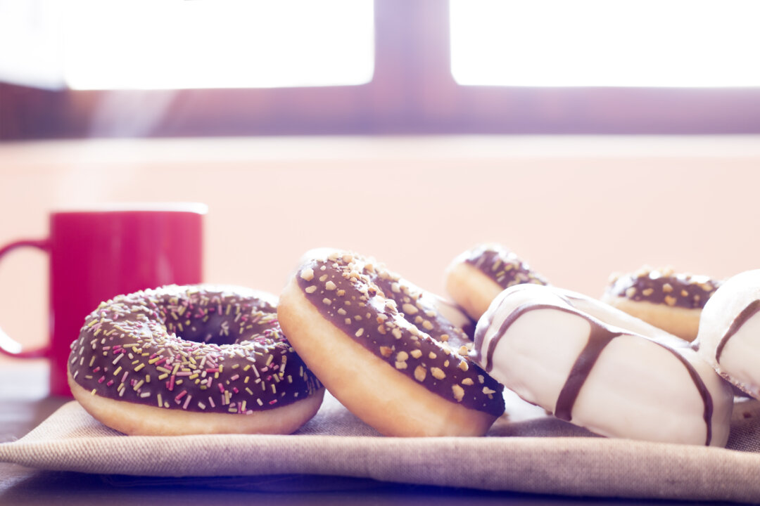 A appetizing group of white chocolate donuts,black chocolate donuts with colorful sweets and other browns
