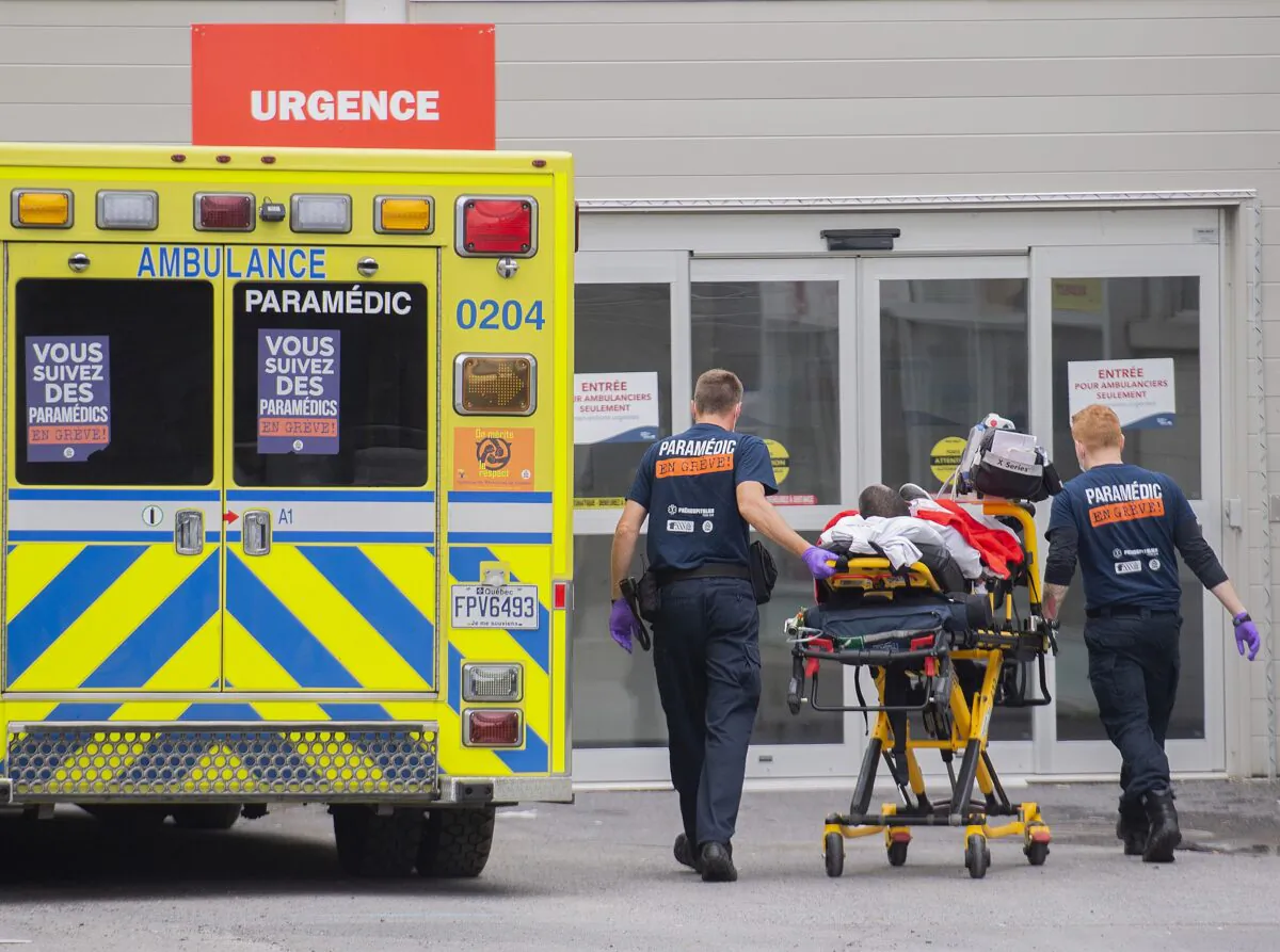Paramedics transfer a patient to a hospital in Montreal on July 14, 2022. (The Canadian Press/Graham Hughes)