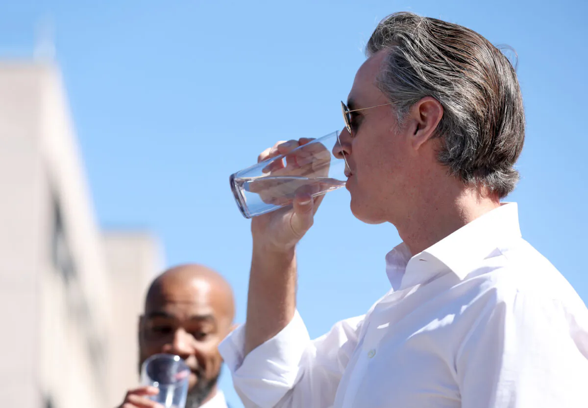California Gov. Gavin Newsom (R) tastes wastewater that was treated at the Antioch Water Treatment Plant with Antioch Mayor Lamar Thorpe (L) in Antioch, Calif., on Aug. 11, 2022. (Justin Sullivan/Getty Images)