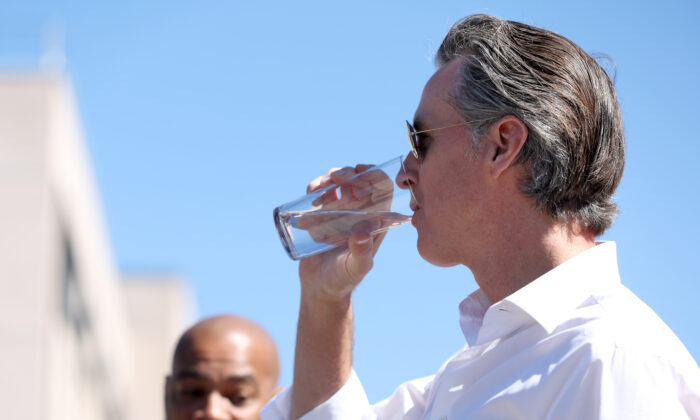 California Gov. Gavin Newsom (R) tastes wastewater that was treated at the Antioch Water Treatment Plant with Antioch Mayor Lamar Thorpe (L) in Antioch, Calif., on Aug. 11, 2022. (Justin Sullivan/Getty Images)
