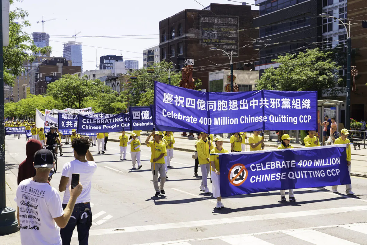 Residents look on as hundreds of people march in a parade to celebrate 400 million Chinese people quitting the Chinese Communist Party and its affiliated organizations, in downtown Toronto on Aug. 6, 2022. (Evan Ning/The Epoch Times)