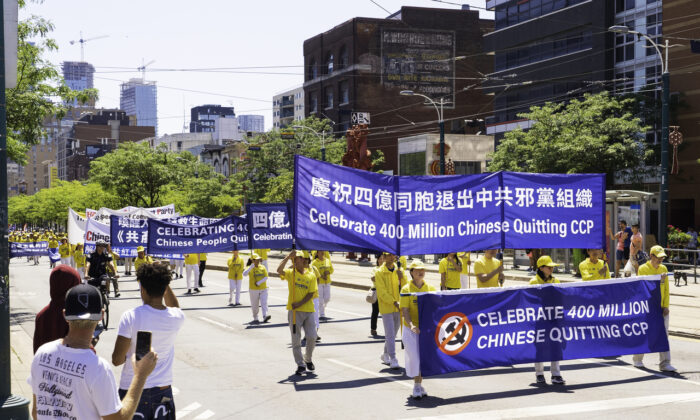 Residents look on as hundreds of people march in a parade to celebrate 400 million Chinese people quitting the Chinese Communist Party and its affiliated organizations, in downtown Toronto on Aug. 6, 2022. (Evan Ning/The Epoch Times)