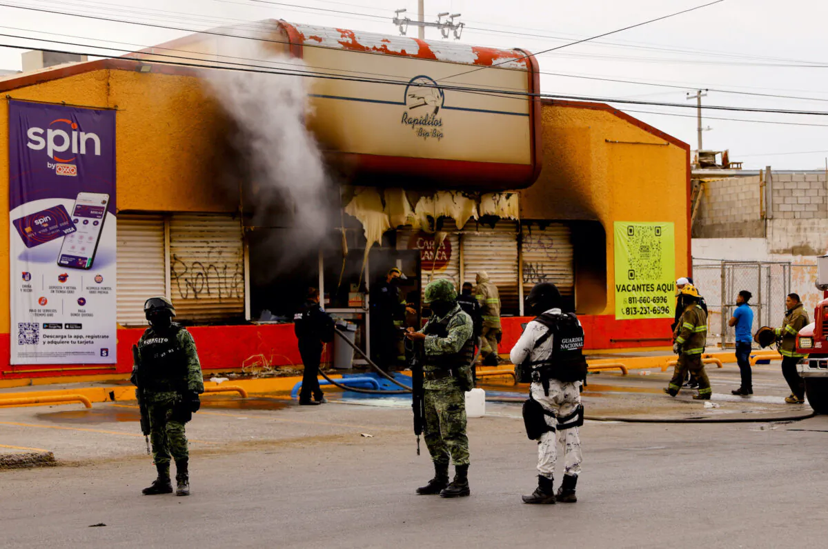 Security forces stand outside a convenience store that was burned by unknown attackers, in a simultaneous attack of fires in different parts of the city, in Ciudad Juarez, Mexico, on Aug. 11, 2022. (Jose Luis Gonzalez/Reuters)
