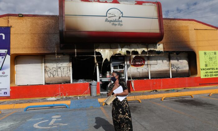 A woman stands in front of the building  where unknown persons burnt down shops in Ciudad Juarez, state of Chihuahua, Mexico, on Aug. 12, 2022. (Herika Martinez/AFP via Getty Images)