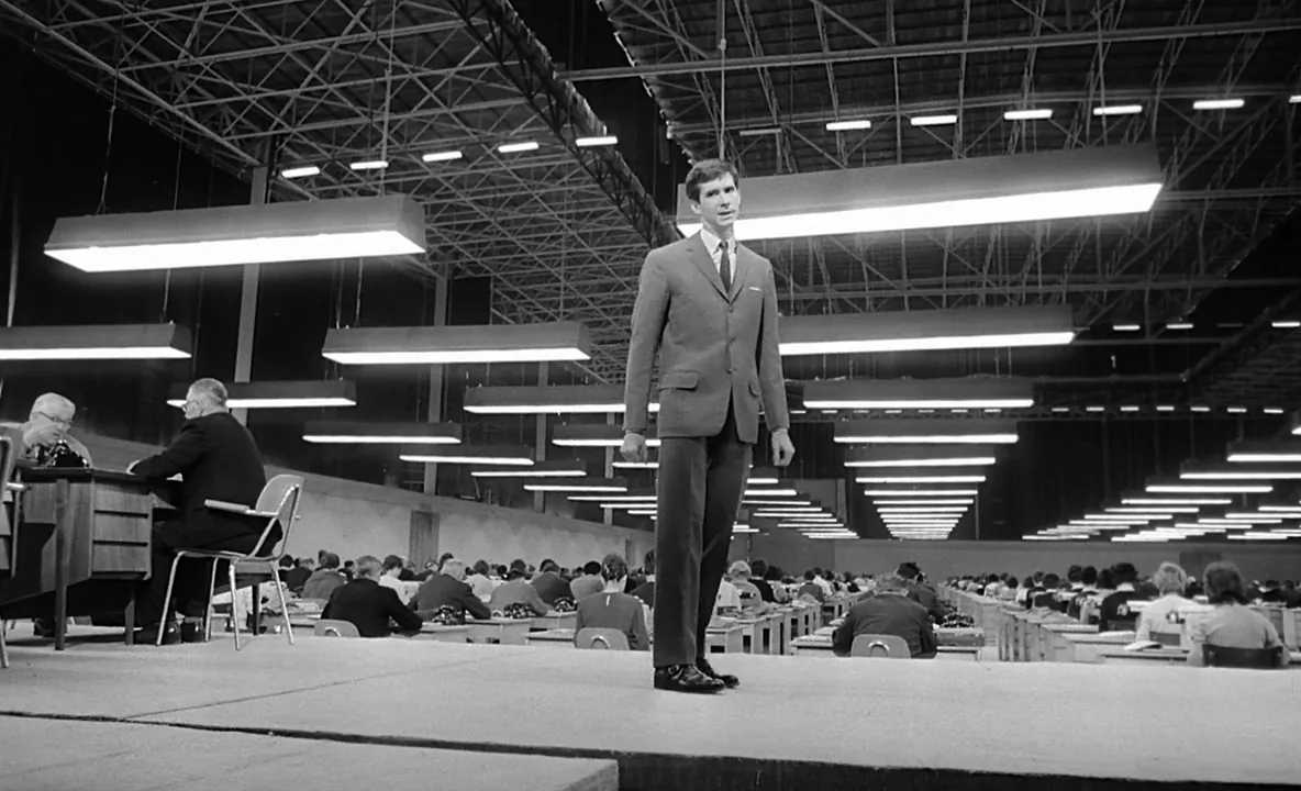 Antony Perkins as K in his hangar-sized office that houses hundreds of workers, who are ant-like, plugging away at thunderous typewriters or telephones, in a scene from "The Trial." (Rialto Pictures/Studiocanal)