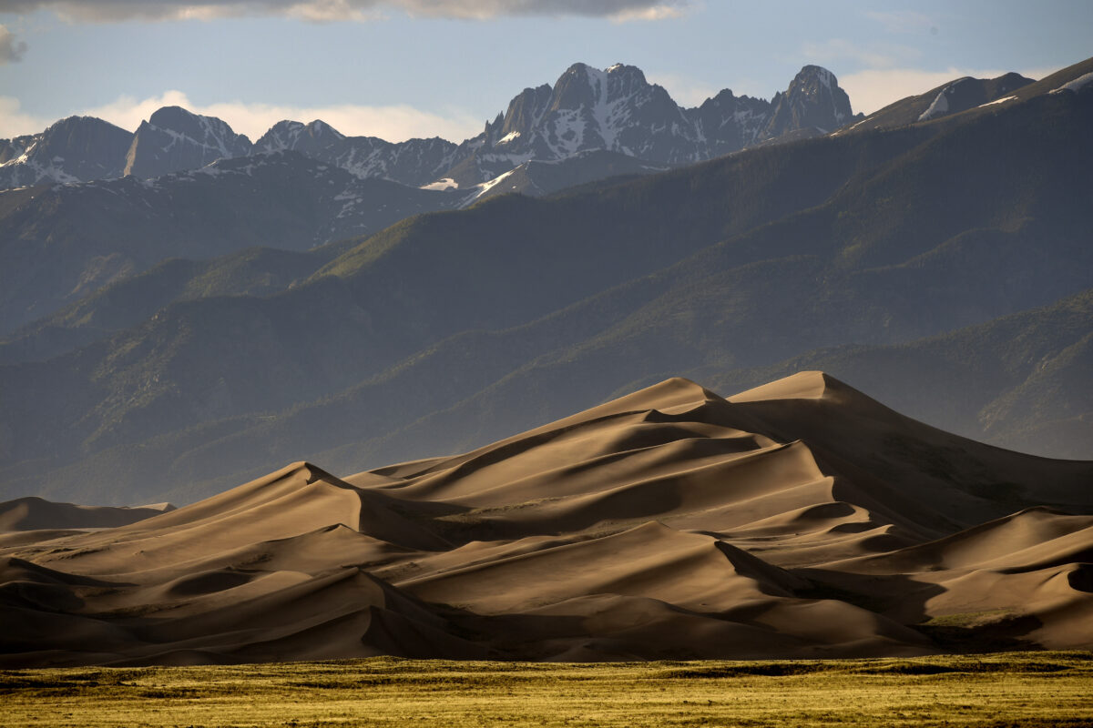 The Great Sand Dunes are lit by the setting sun on June 19, 2019 in Mosca, Colorado. Great Sand Dunes National Park and Preserve is known for huge dunes like the towering Star Dune, and for the seasonal Medano Creek and beach created at the base of the dunes. These sand dunes are the tallest dunes in North America. (Helen H. Richardson/The Denver Post/TNS)