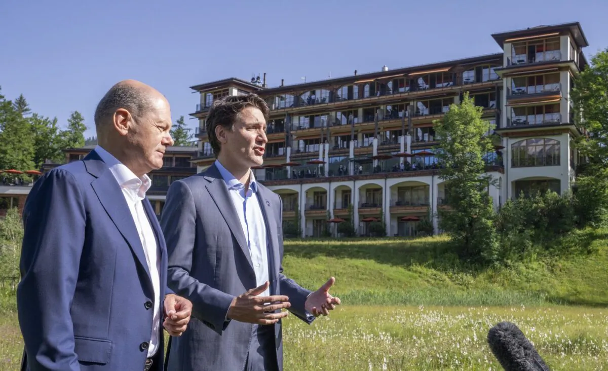 Prime Minister Justin Trudeau and Olaf Scholz, Chancellor of Germany stop to talk to the media as they take a stroll at the G7 Summit in Schloss Elmau on June 27, 2022. (The Canadian Press/Paul Chiasson)