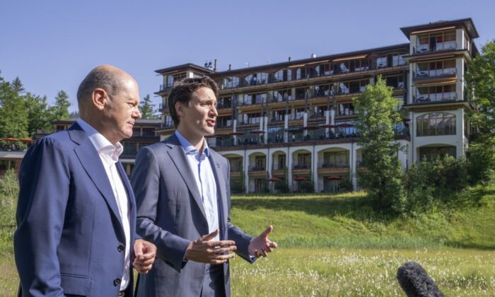 Prime Minister Justin Trudeau and Olaf Scholz, Chancellor of Germany stop to talk to the media as they take a stroll at the G7 Summit in Schloss Elmau on June 27, 2022. (The Canadian Press/Paul Chiasson)