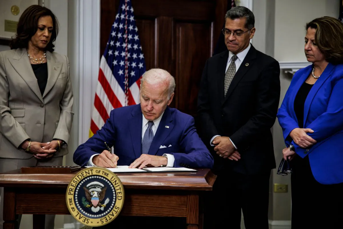 President Joe Biden signs an executive order directing the Department of Health and Human Services to ensure access to abortions while Vice President Kamala Harris, HHS Secretary Xavier Becerra, and Deputy Attorney General Lisa Monaco look on at the White House in Washington on July 8, 2022. (Samuel Corum, AFP/Getty Images)