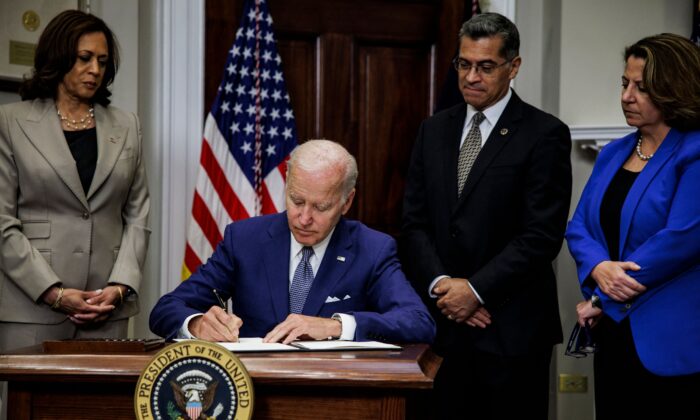 President Joe Biden signs an executive order directing the Department of Health and Human Services to ensure access to abortions while Vice President Kamala Harris, HHS Secretary Xavier Becerra, and Deputy Attorney General Lisa Monaco look on at the White House in Washington on July 8, 2022. (Samuel Corum, AFP/Getty Images)