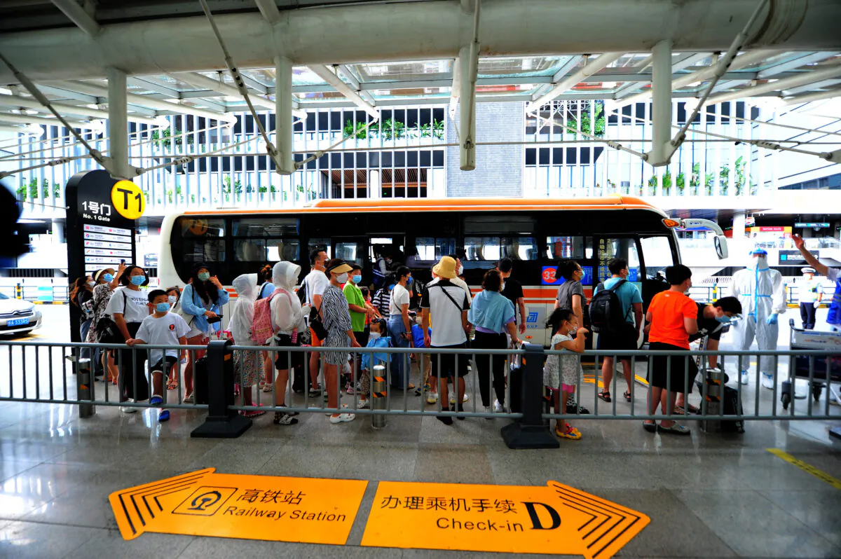 People go through pre-departure formalities at the Sanya Phoenix International Airport as tourists prepare to leave the COVID-19-hit resort city of Sanya on Hainan Island, China on Aug. 9, 2022. (STR/AFP via Getty Images)