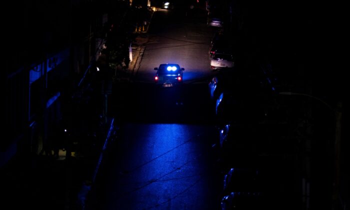 A police car patrols a dark street in San Juan, Puerto Rico, on June 10, 2021. (Ricardo Arduengo/AFP via Getty Images)
