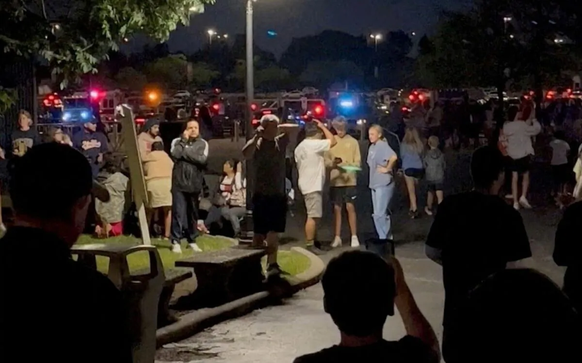 People walk towards emergency vehicles after a shooting at the Six Flags Great America amusement park in Gurnee, Ill., on Aug. 14, 2022, in this screengrab obtained from a social media video. (Jack via Reuters)