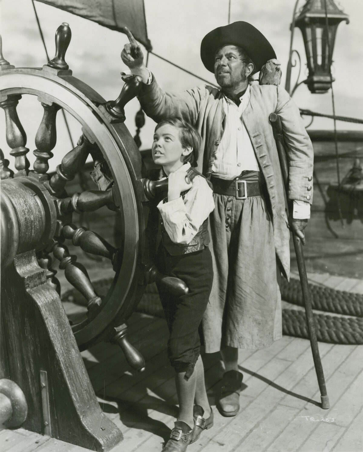 Bobby Discoll as Jim Hawkins and  Robert Newton as Long John Silver in the 1950 film “Treasure Island.” RKO Radio Pictures, Walt Disney Pictures. (MoviestillDB)