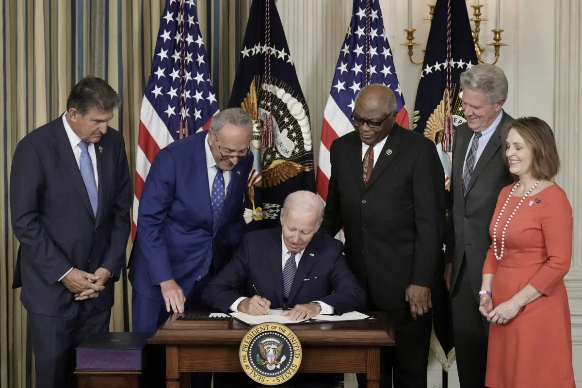 President Joe Biden signs the Inflation Reduction Act as Democrat lawmakers look on at the White House in Washington on Aug. 16, 2022. (Drew Angerer/Getty Images)