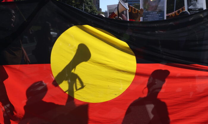 Protesters are seen through an Aboriginal flag during a rally in Sydney, Australia, on April 10, 2021. (David Gray/Getty Images)