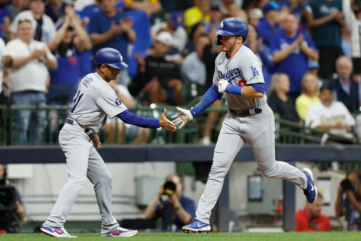 Gavin Lux #9 of the Los Angeles Dodgers celebrates his two-run home run with third base coach Dino Ebel #91 in the sixth inning against the Milwaukee Brewers at American Family Field in Milwaukee, on August 15, 2022. (John Fisher/Getty Images)