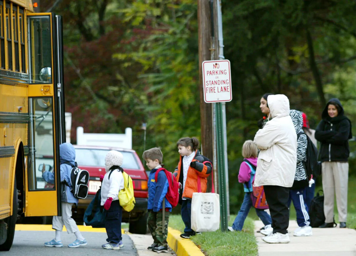 Parents watch as children step onto a Fairfax County school bus at Police headquarters in Falls Church, Virginia, on Oct. 15, 2002.   (Mark Wilson/Getty Images)
