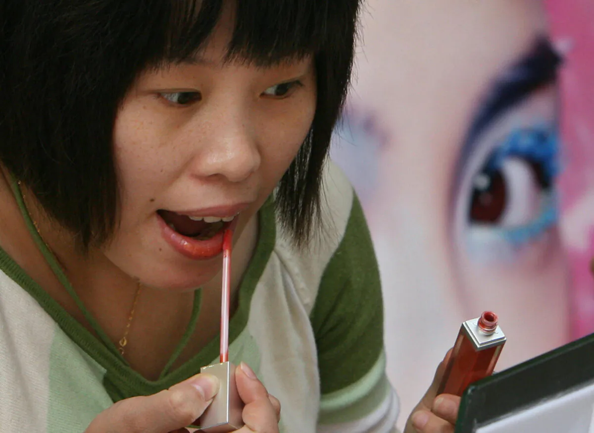 A Chinese woman tries out cosmetics during a beauty product promotion at the Nanjing Road shopping area of Shanghai, Oct. 23, 2007. (Mark Ralston/AFP via Getty Images)