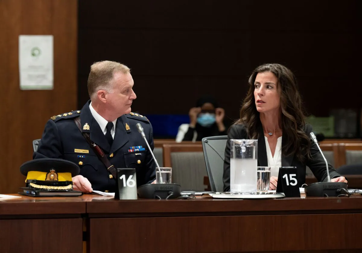 RCMP Chief Supt. Darren Campbell speaks with Director of Strategic Communications Unit Lia Scanlan as they wait to appear before the Standing Committee on Public Safety and National Security in Ottawa on Aug. 16, 2022. (The Canadian Press/Adrian Wyld)