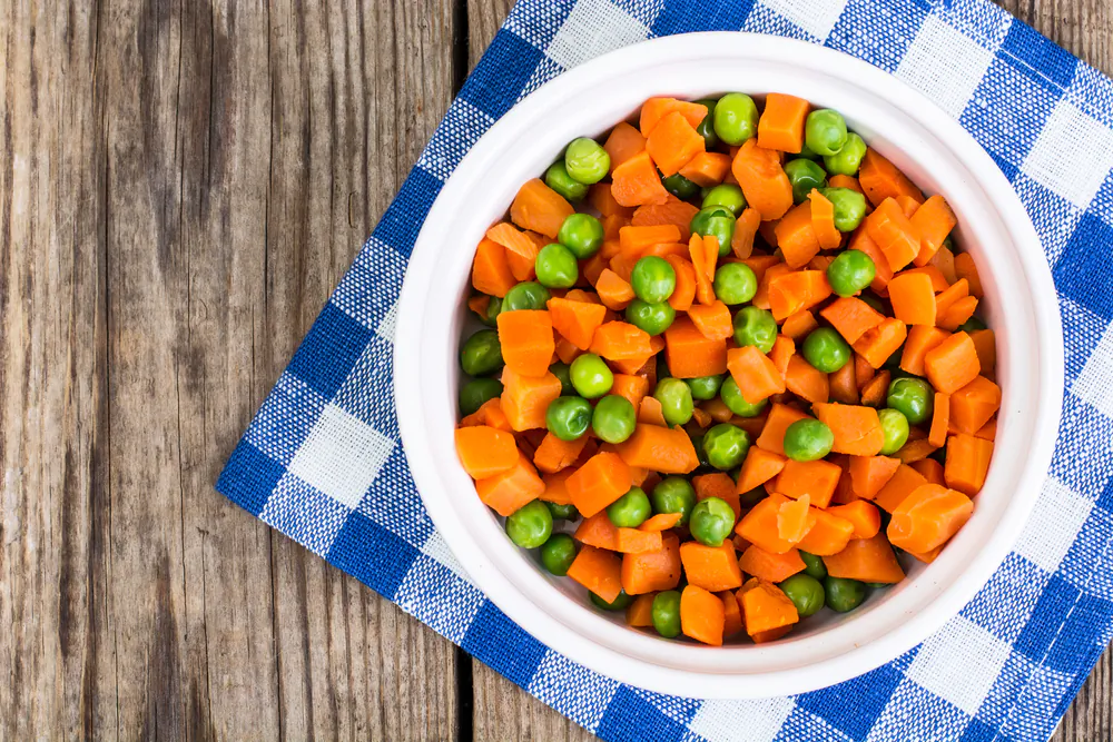 To make this frozen-bag staple properly, cut the carrots down to pea-size and cook them separately in salted water, until softened but not mushy. (ArtCookStudio/Shutterstock)
