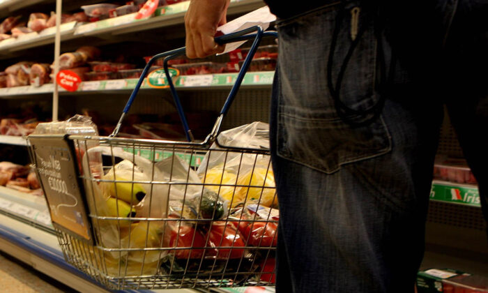未注明日期的档案照片，一名男子在超市提着购物篮。  （朱利安·贝哈尔/PA Media）
