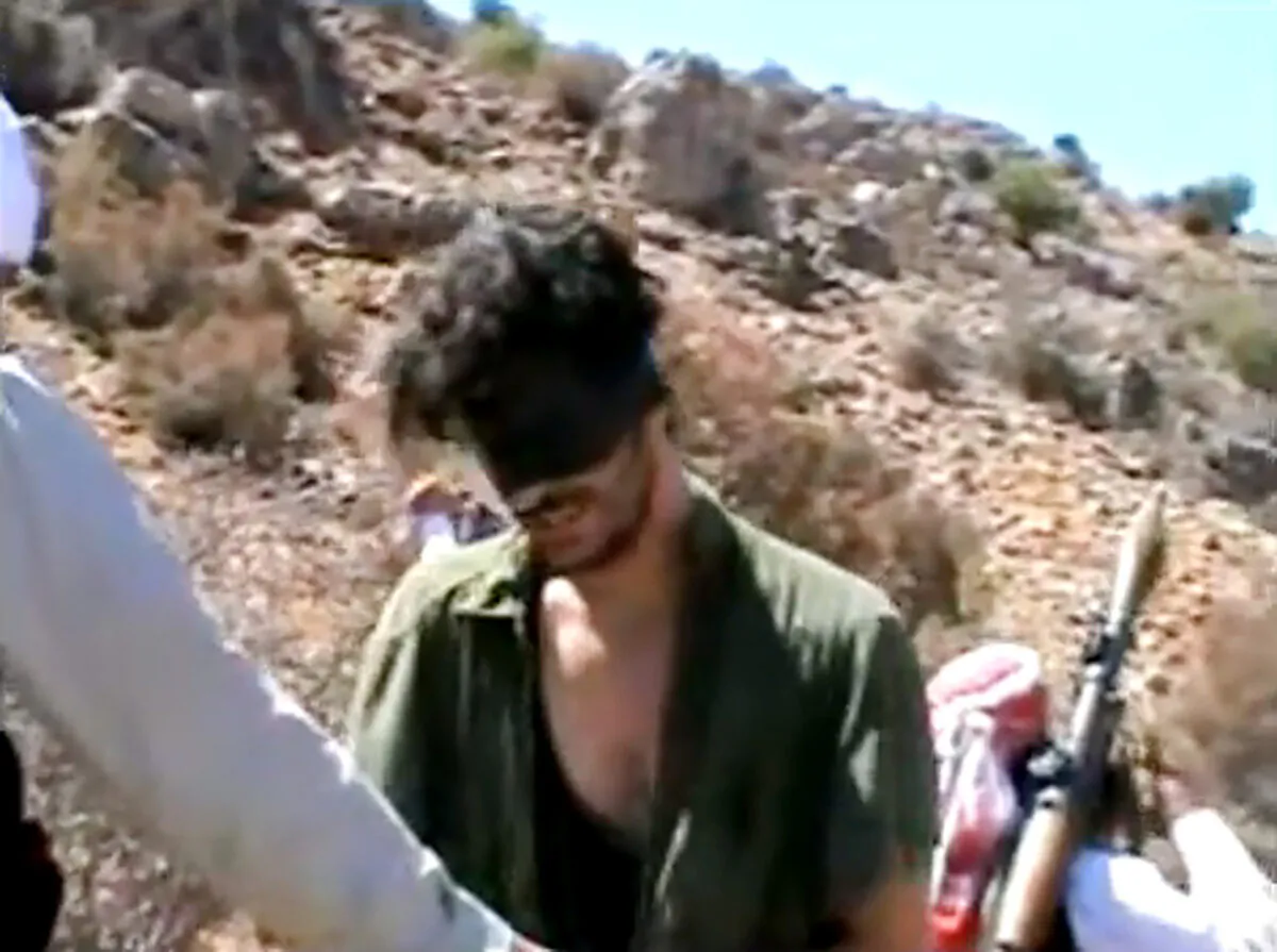 American freelance journalist Austin Tice, who had been reporting for American news organizations in Syria until his disappearance in August 2012, prays in Arabic and English while blindfolded in the presence of gunmen, in a still from undated video posted to YouTube. (AP Photo)