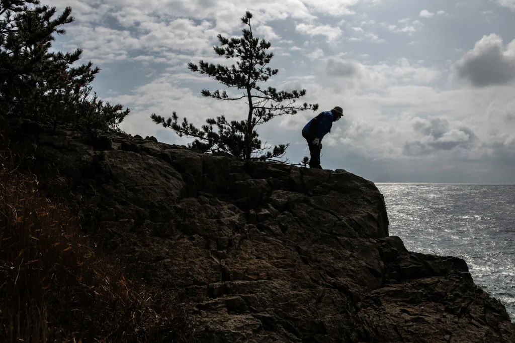 A man looks along the clifftop during a suicide prevention patrol at Tojinbo cliffs in Tojinbo, Japan, on Feb. 23, 2021. (Carl Court/Getty Images)