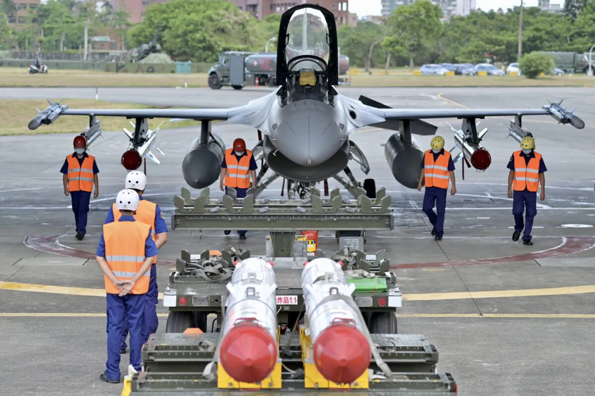 Taiwan air force soldiers clear the ground in front of an armed F-16V fighter jet during a drill at Hualien air force base in Hualien County, Taiwan, on Aug. 17, 2022. (Sam Yeh/AFP via Getty Images)
