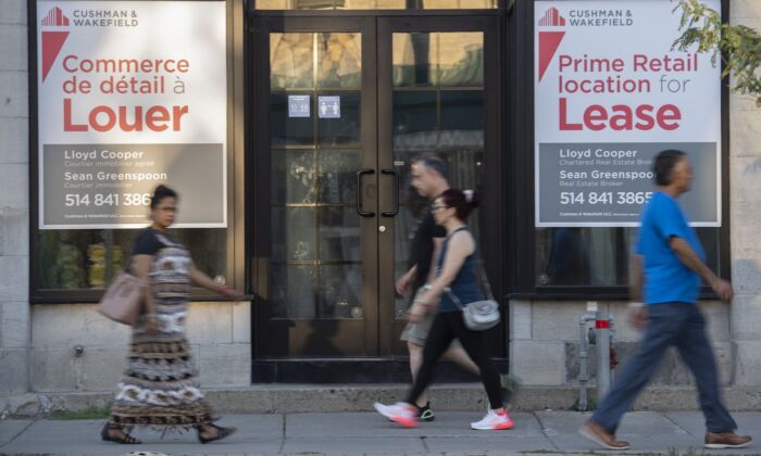 People walk by bilingual signs for a commercial space for lease in the city of Westmount on the island of Montreal on Aug. 5, 2022. (The Canadian Press/Graham Hughes)