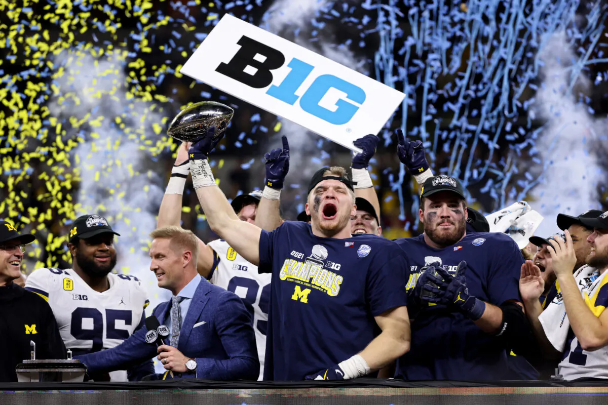 Aidan Hutchinson #97 of the Michigan Wolverines celebrates with the trophy after the Michigan Wolverines defeated the Iowa Hawkeyes 42-3 to win the Big Ten Championship game at Lucas Oil Stadium in Indianapolis, on December 4, 2021. (Dylan Buell/Getty Images)