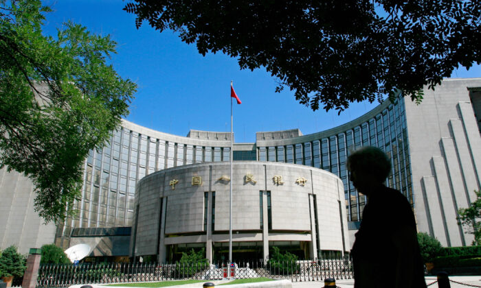 2007 年 8 月 9 日，行人走过位于北京市中心的中国人民银行，也称为中国中央银行。（Teh Eng Koon/AFP via Getty Images）