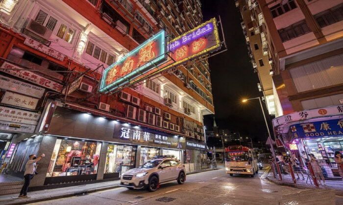 The last night the neon signs of the long-established "Koon Nam Wah" in Yau Ma Tei were displayed, on Aug. 16, 2022. Red minibuses and neon signs are unique characteristics of Hong Kong. (TM Chan /The Epoch Times)