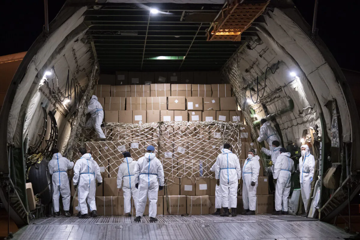 A crew get ready to unload medical supplies from an Antonov AN-225 cargo transporter upon arriving from China at Mirabel Airport in Mirabel, Que. on May 1, 2020. (The Canadian Press/Paul Chiasson)