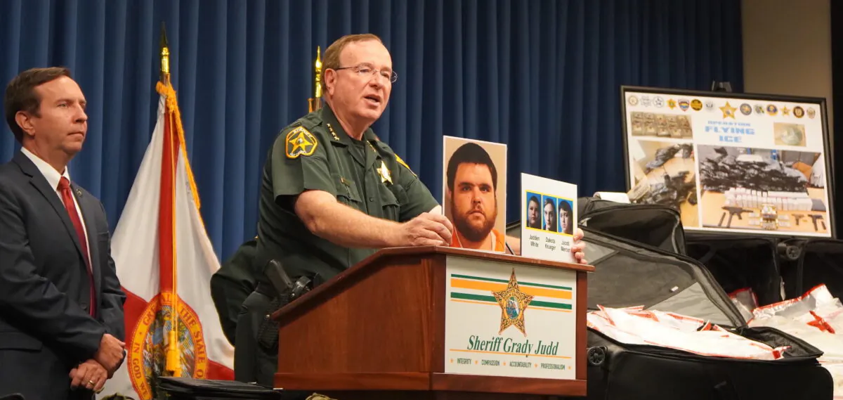 Polk County Sheriff Grady Judd shows the media pictures of suspects after busting an international drug ring on Aug. 19, 2022 (Jann Falkenstern/The Epoch Times)