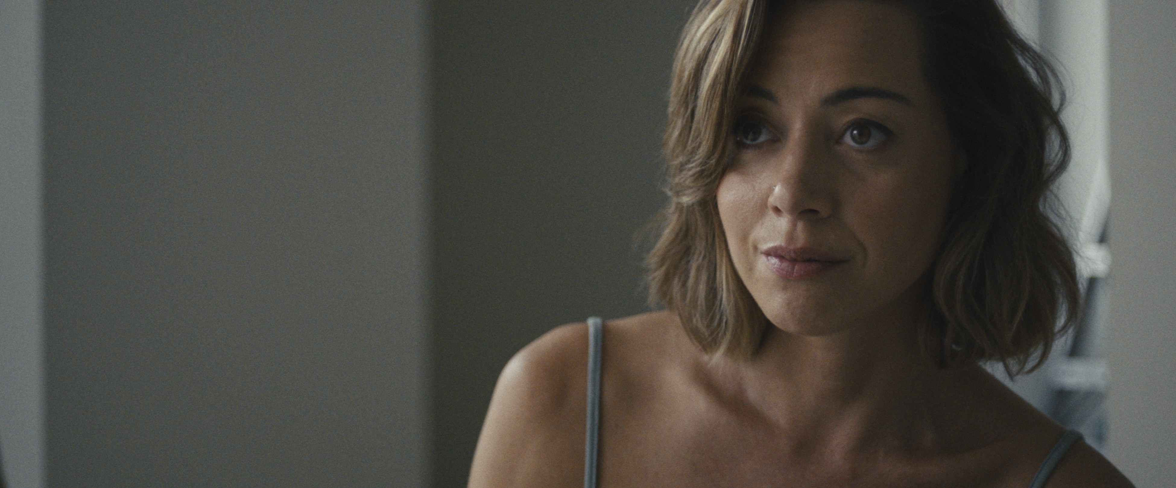 woman in grey tank top in EMILY THE CRIMINAL