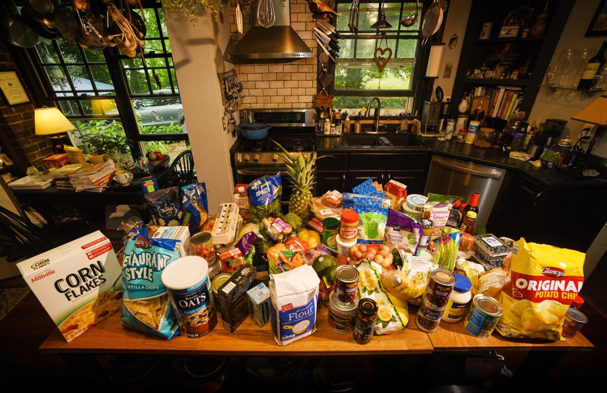 Piled on the kitchen table of food writer Pittsburgh Post-Gazette Gretchen McKay are more than 60 ingredients that she purchased for less than $200 in Ben Avon on Thursday, July 21, 2022. The ingredients will be used to provide a week's worth of meals for a family of four. (Steve Mellon/Pittsburgh Post-Gazette/TNS)